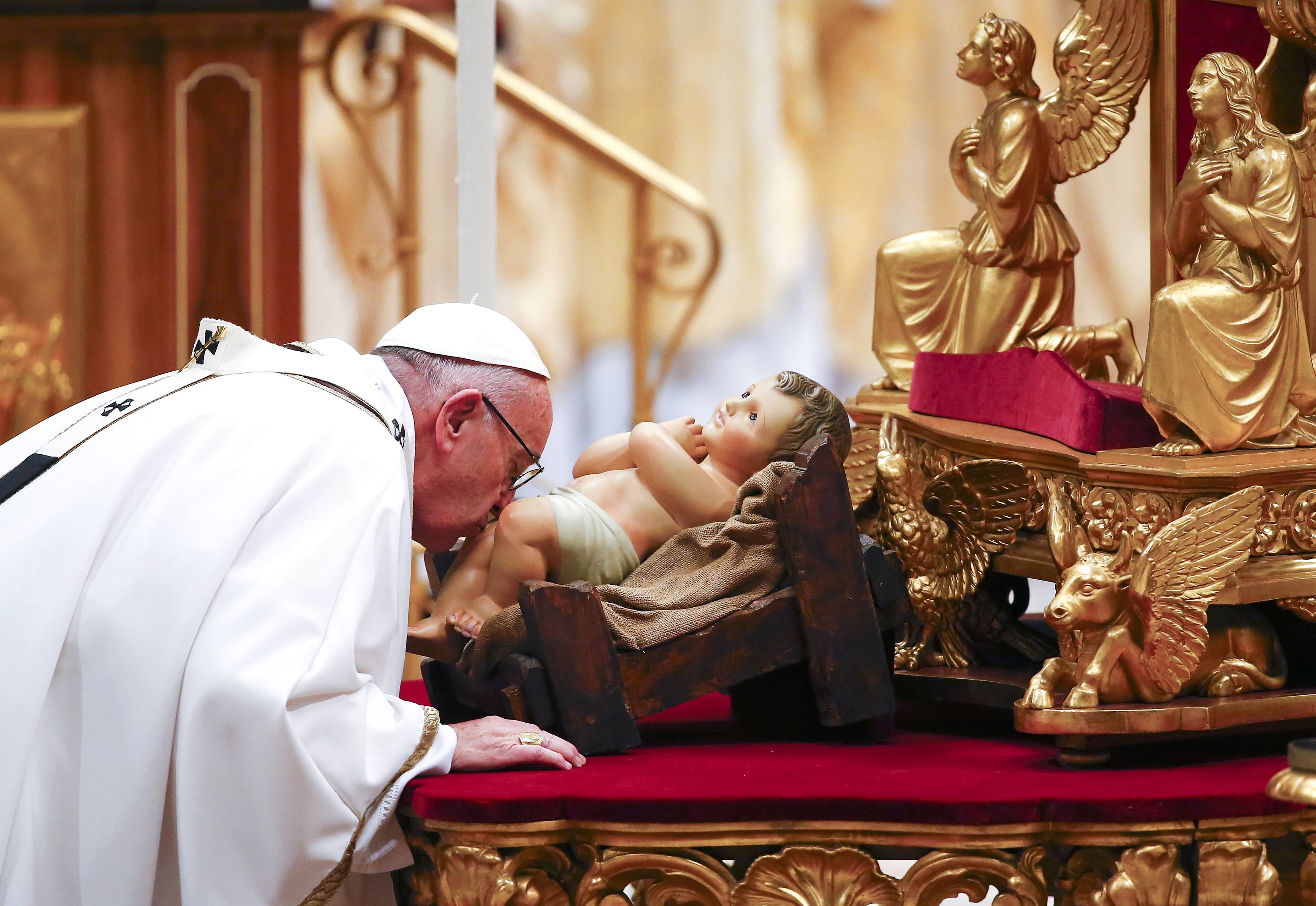 Pope Francis kisses a statue of baby Jesus as he leads the Christmas night Mass in Saint Peter's Basilica at the Vatican December 24, 2016. REUTERS/Tony Gentile TPX IMAGES OF THE DAYn