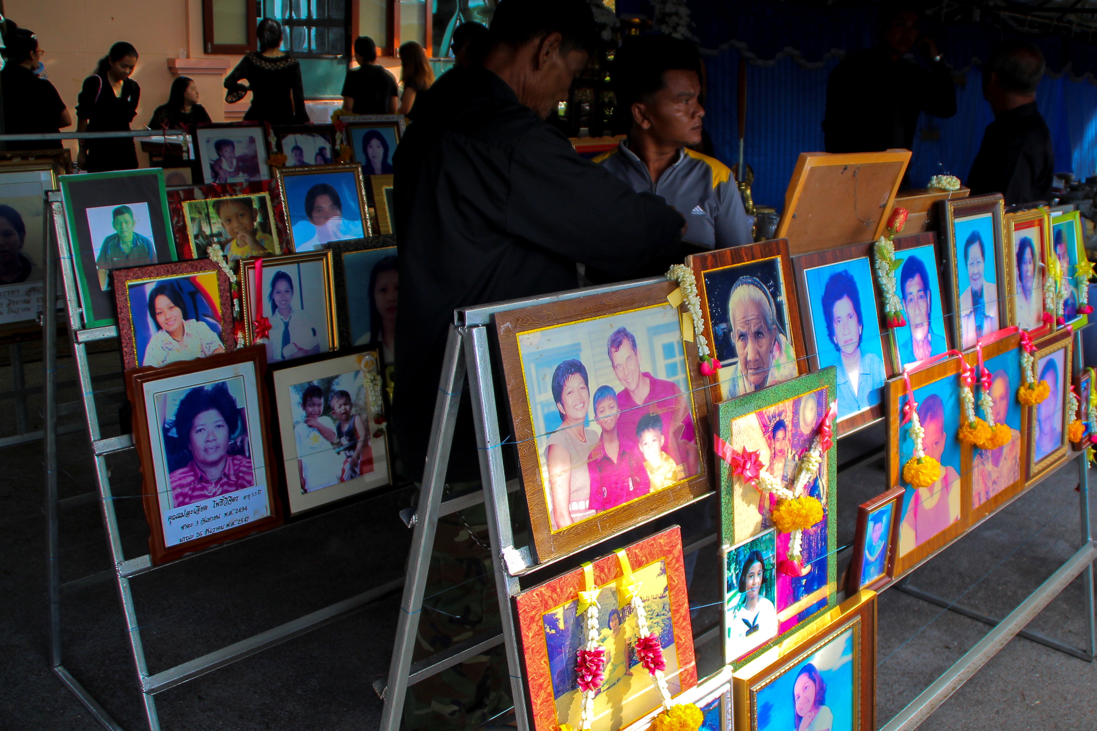 People stand next to pictures of victims of the 2004 tsunami victims during a religious ceremony in Ban Nam Khem, a southern fishing village destroyed by the wave in Phang Nga Province, Thailand, December 26, 2016. Dailynews/via REUTERS ATTENTION EDITORS 