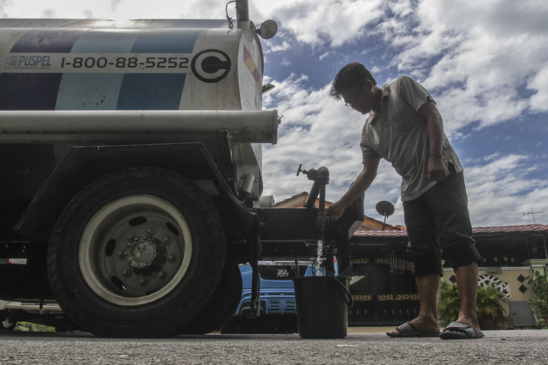 A resident of Bandar Baru Sultan Suleiman collects water from Syabas tank truck in Port Klang December 21, 2016. u00e2u20acu201d Picture by Yusof Mat Isa
