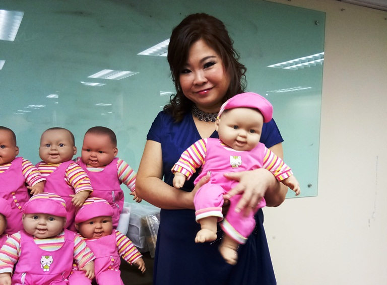 香港资深陪月专家黄小玉抱着示范婴儿娃娃。-M中文网摄-