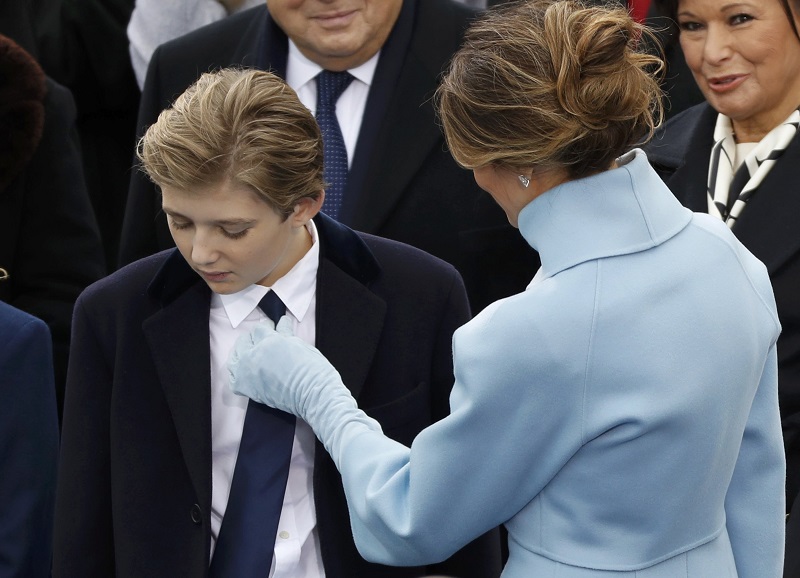 梅拉尼娅（右）在就职典礼上为儿子巴伦整理领带。-路透社-