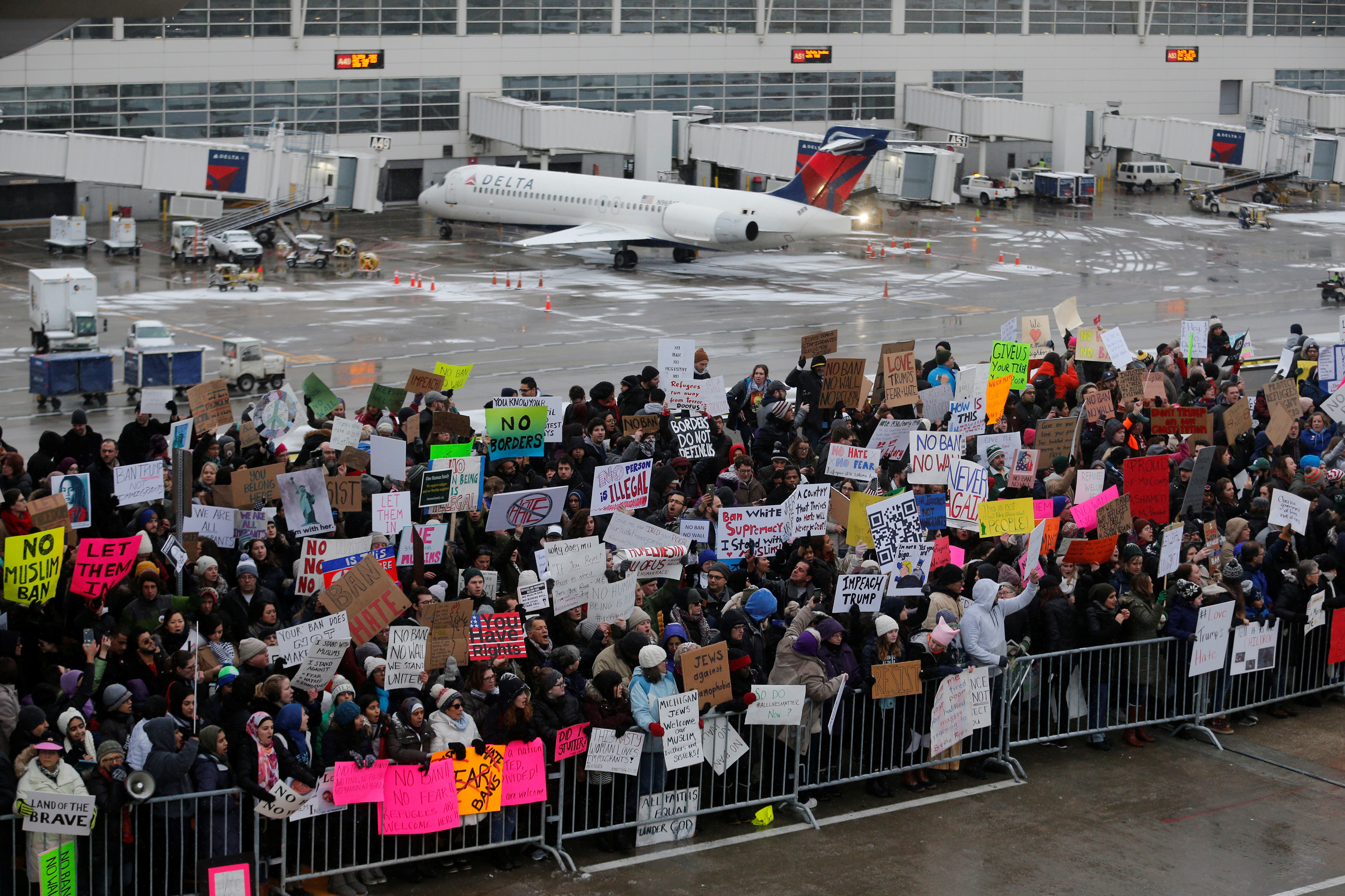 Hundreds of people rally against a travel ban signed by U.S. President Donald Trump in an executive order, during a protest at Detroit Metropolitan airport in Romulus, Michigan, U.S., January 29, 2017. REUTERS/Rebecca Cook TPX IMAGES OF THE DAYn