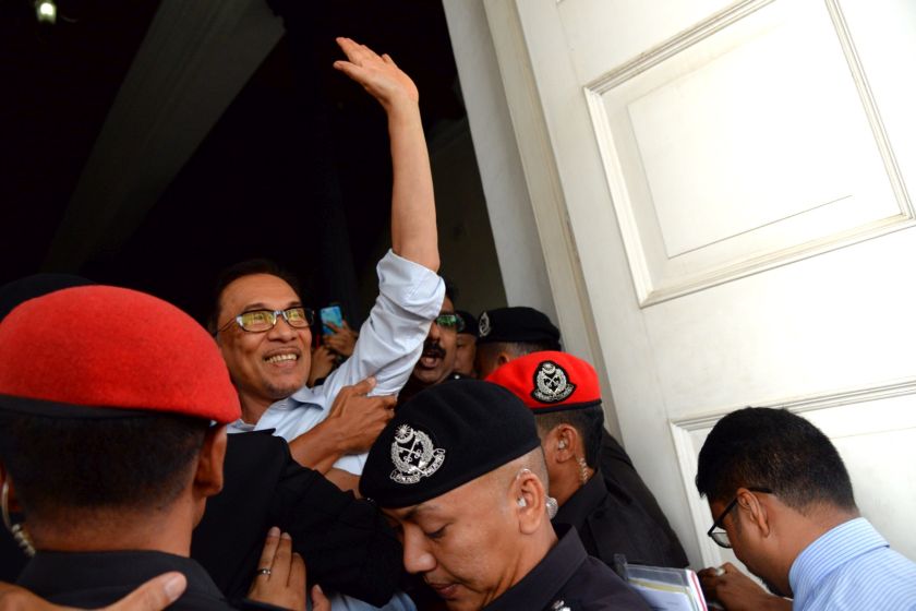 Anwar Ibrahim waves to the crowd as he arrives at the Penang High Court for the hearing of his defamation suit against the New Straits Times on January 9, 2017. u00e2u20acu201d Picture by KE Ooi