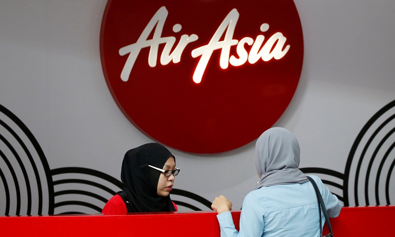 An AirAsia counter staff attends to a customer at Kuala Lumpur International Airport (KLIA) August 28, 2016. u00e2u20acu201d Reuters pic