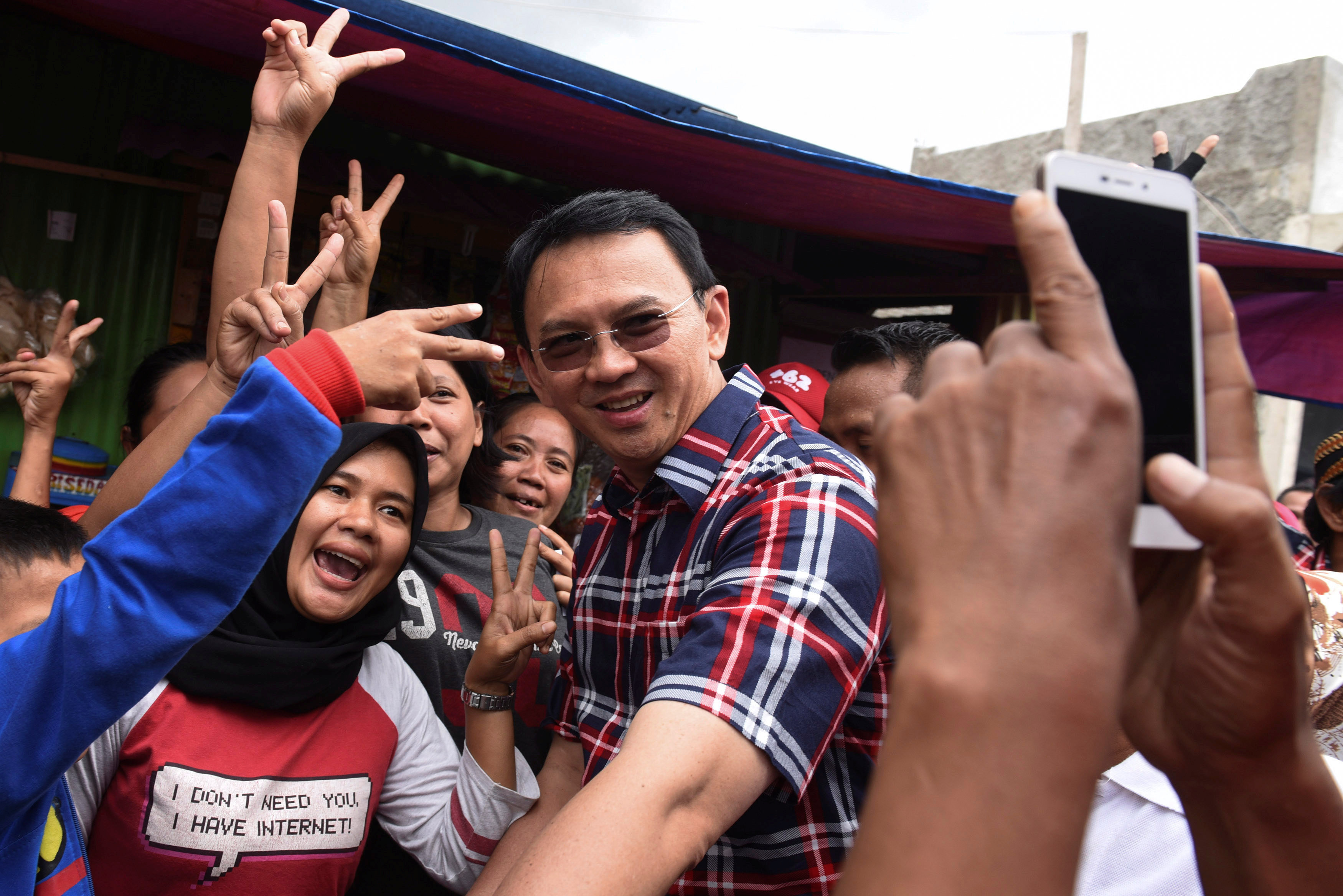 Jakarta governor Basuki Tjahaja Purnama (C) take pictures with residents during his campaign at Jatinegara district in Jakarta, Indonesia, February 6, 2017 in this photo taken by Antara Foto. Picture taken February 6, 2017. Antara Foto/Hafidz Mubarak/ via