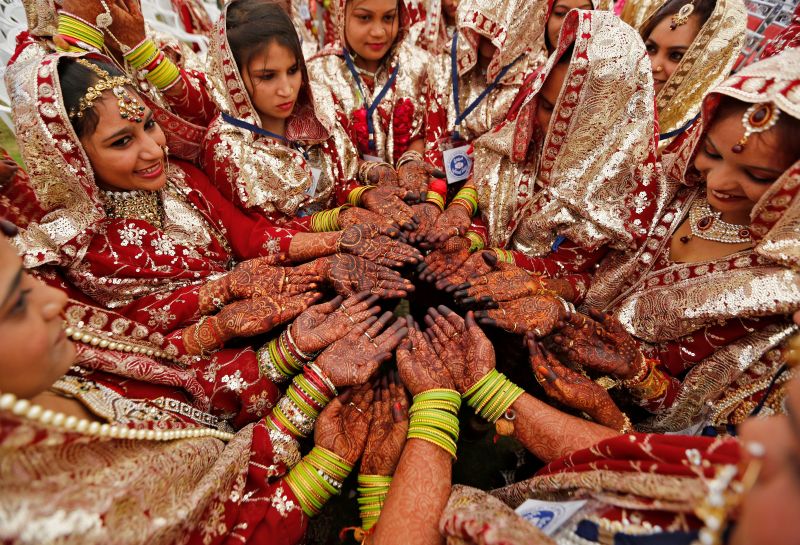 Brides pose as they display their hands decorated with henna before taking their wedding vows during a mass marriage ceremony in which, according to its organisers, 131 Muslim couples took their wedding vows in Ahmedabad, India, February 26, 2017. u00e2u20acu201d Reu