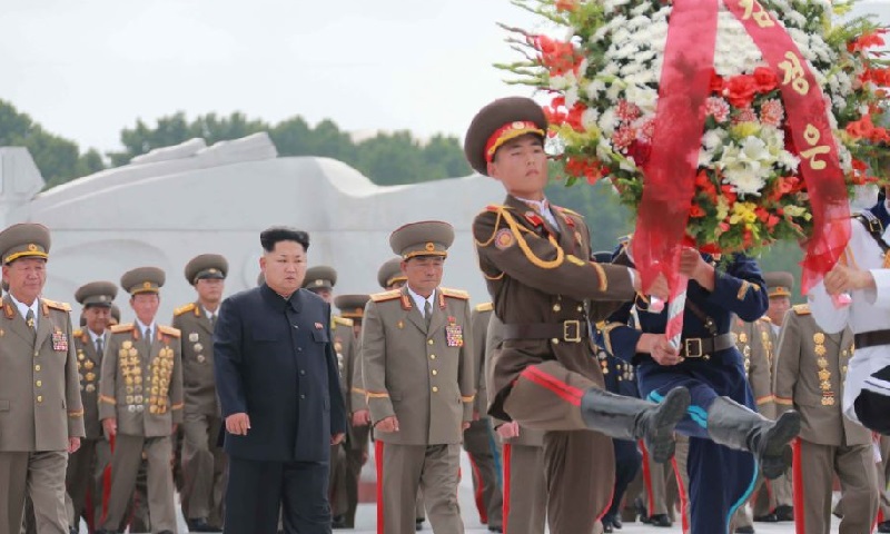 2015年7月27日，金正恩（中）在朝鲜解放战争胜利纪念日当天，向位于平安南道桧仓郡的中国人民志愿军烈士陵园送花圈。-路透社/朝中社-