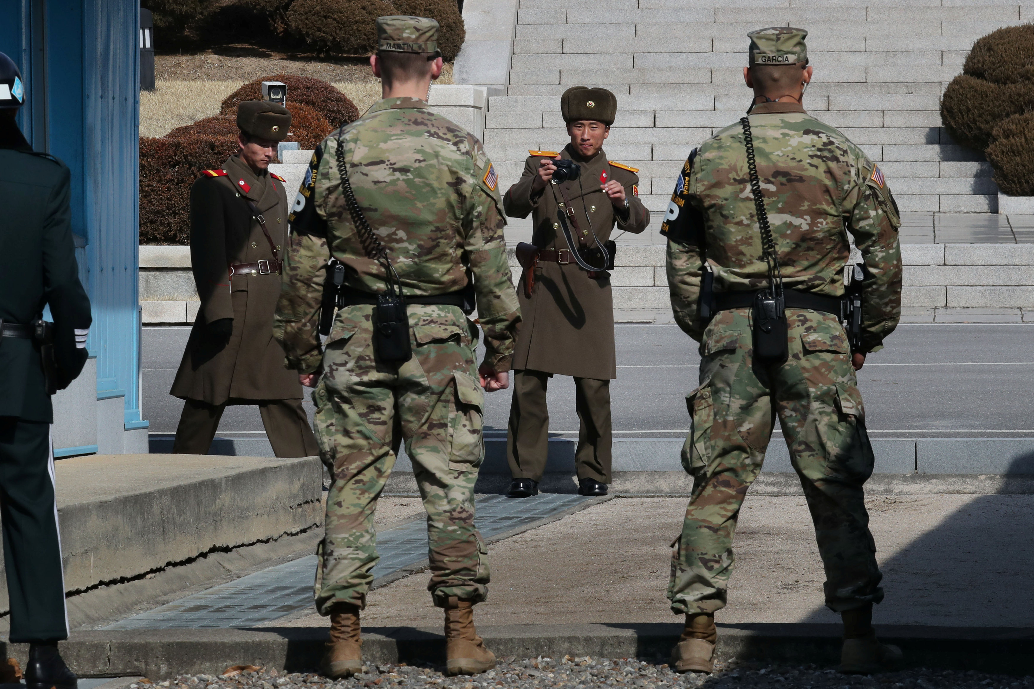 U.S. army soldiers stand guard as a North Korean soldier takes photographs during Australian Foreign Minister Julie Bishop's visits to the truce village of Panmunjom, South Korea, February 18, 2017. Lim Byung-sik/Yonhap via REUTERS n