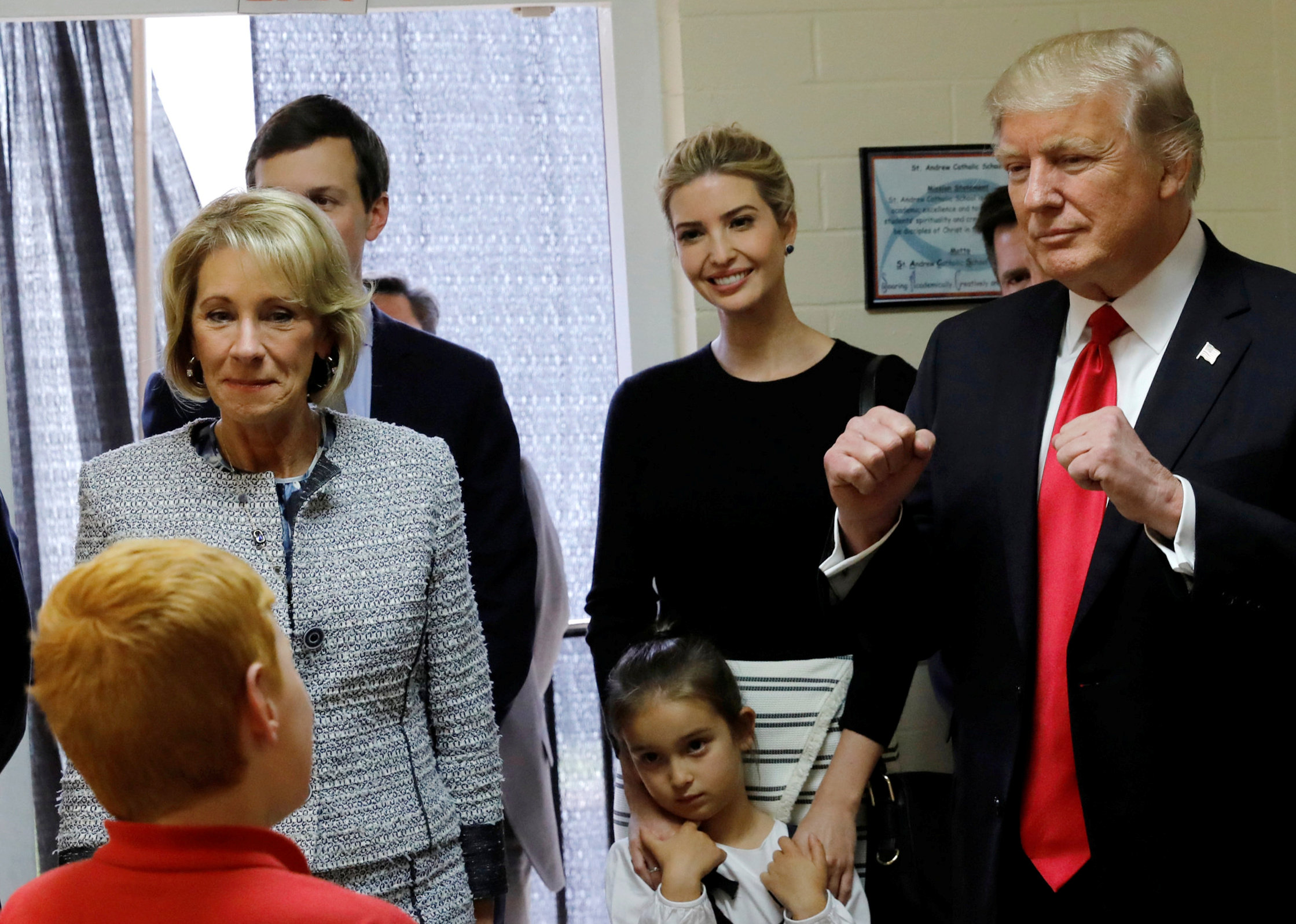 U.S. President Donald Trump (R), joined by Education Secretary Betsy DeVos, his daughter Ivanka Trump and his granddaughter Arabella Kushner, gives a fist-pump when schoolchildren tell him their two goals are ,college and heaven, during a visit to their c