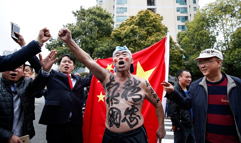 中韩大战上演前,场外有球迷力撑中国队,在身上写上“精忠报国”大字。-路透社-