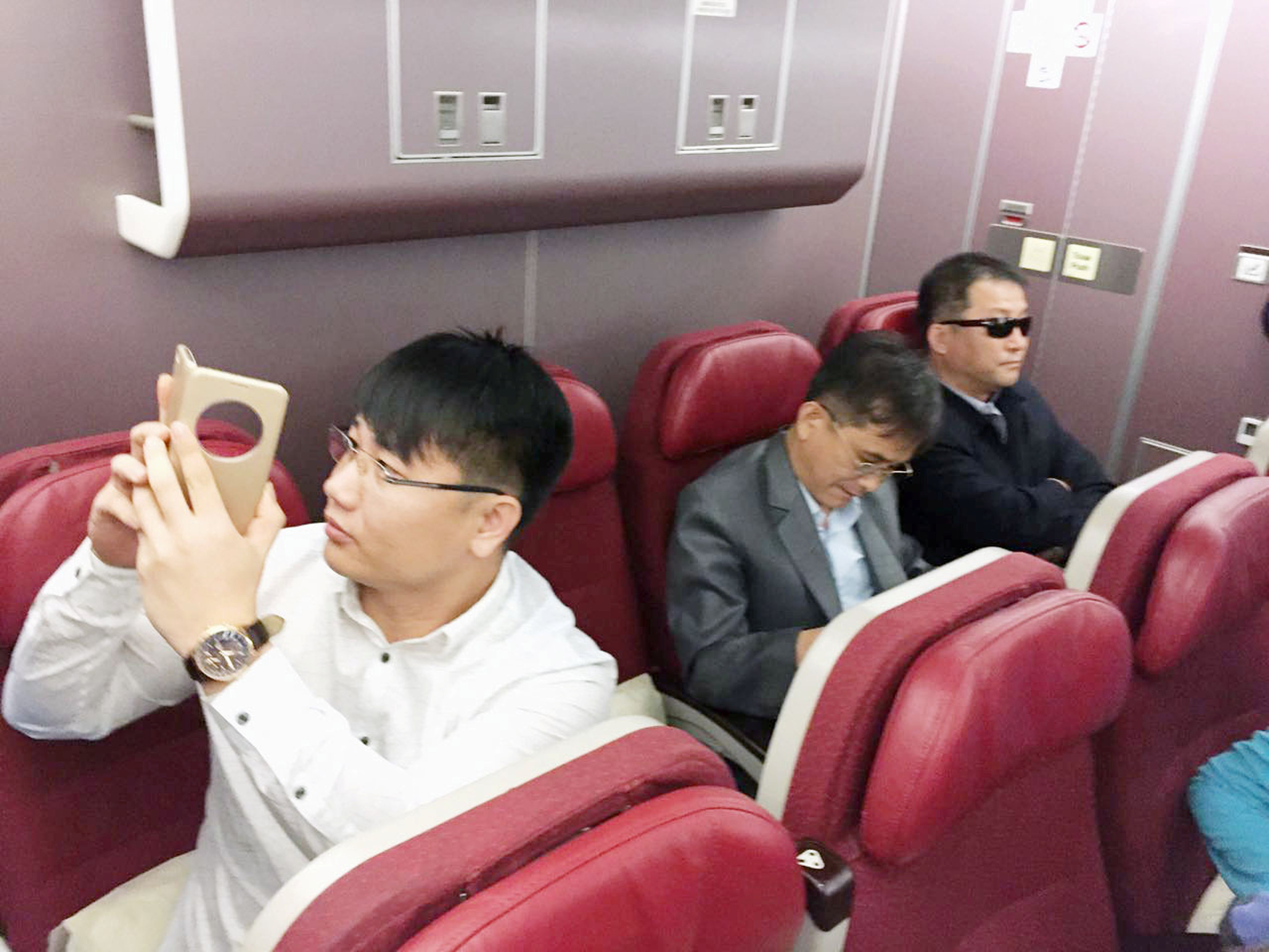 Passengers believed to be North Koreans including Kim Uk Il (L) are seen inside an airplane for the flight bound for Beijing, at an airport in Kuala Lumpur in Malaysia, in this photo taken by Kyodo March 30, 2017. Mandatory credit Kyodo/via REUTERS ATTENT