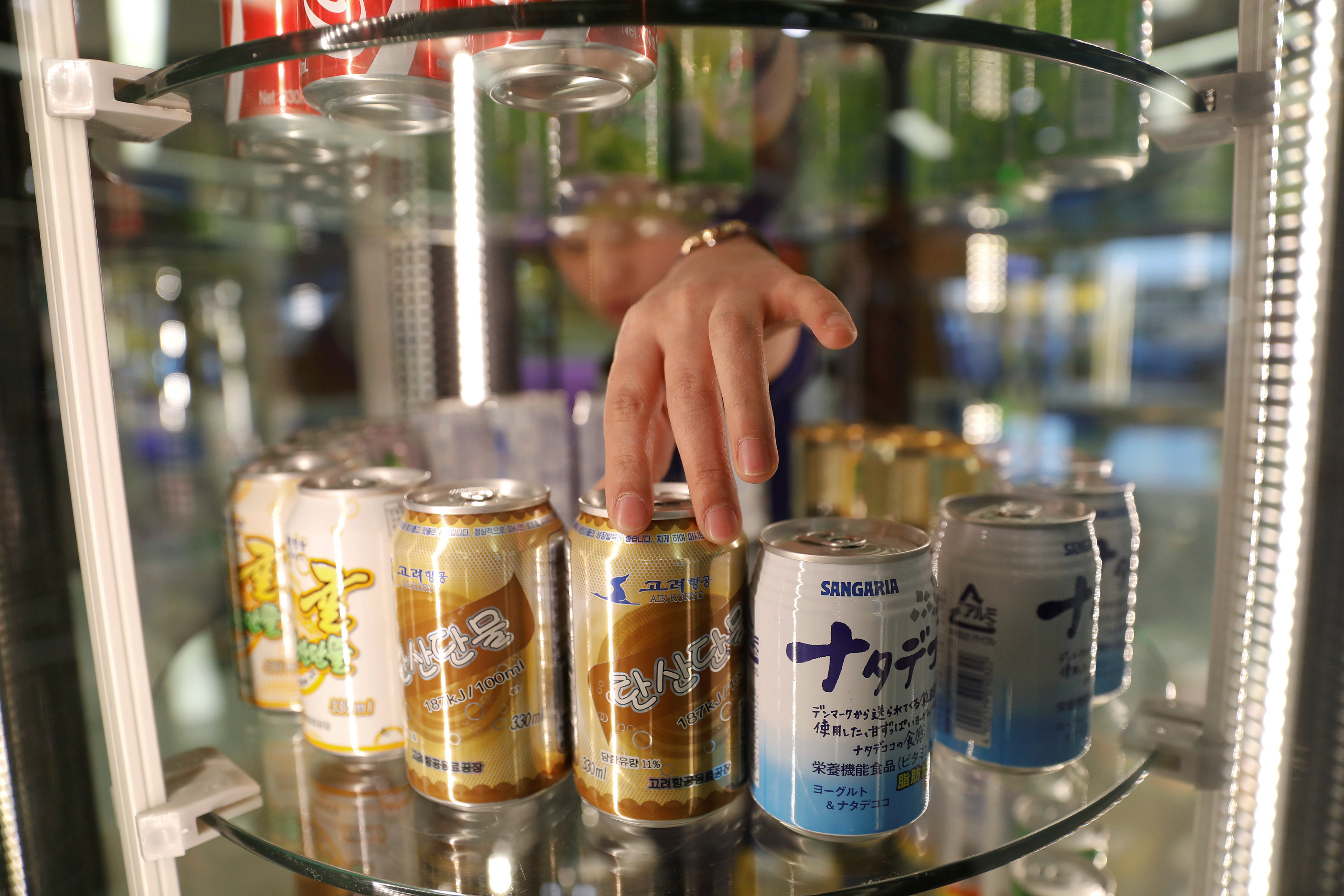 A vendor adjusts cans of soft drinks made by Air Koryo, at the airport in Pyongyang, North Korea April 11, 2017. Picture taken April 11, 2017. REUTERS/Damir Sagoljn