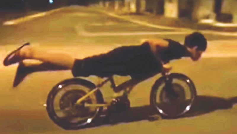 A youth does a stunt on his u00e2u20acu02dclajaku00e2u20acu2122 bicycle on and open road. u00e2u20acu201d Picture by Malay Mail