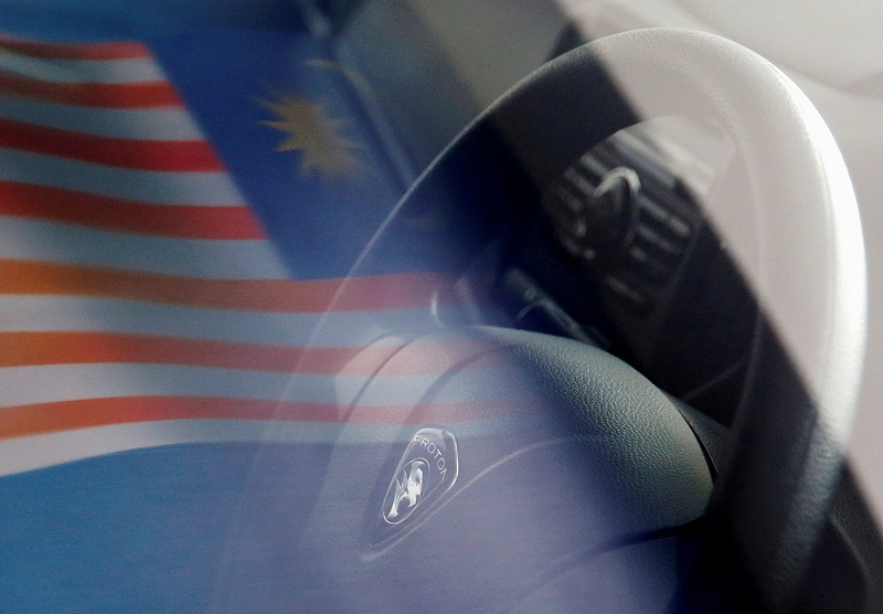 A Malaysian flag is reflected on a car window at a Proton showroom in Puchong, Malaysia October 3, 2016. u00e2u20acu201d Reuters pic