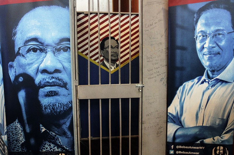 Pictures of Datuk Seri Anwar Ibrahim is seen behind a replica of a prison cell, symbolising the free Anwar Ibrahim campaign during the 12th PKR National Congress in Shah Alam May 21, 2017. u00e2u20acu201d Picture by Yusof Mat Isann