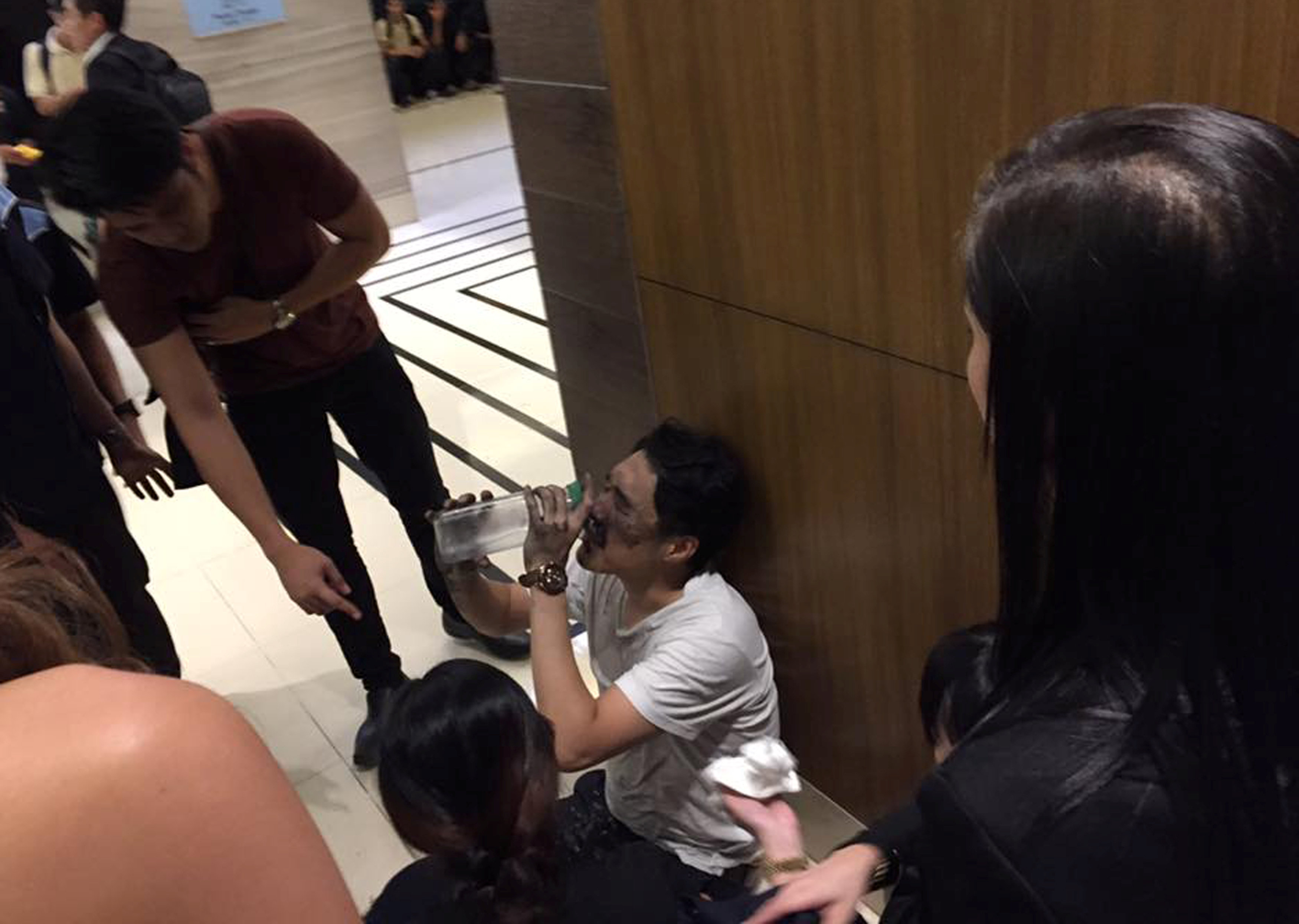 其中一名男赌客被浓烟呛伤，在逃离火场后不停灌水舒缓不适。-路透社-