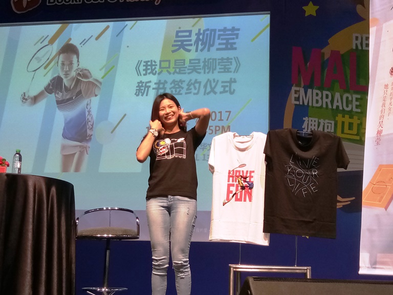 吴柳莹介绍她身上穿的和挂着，由她自己设计的T恤以及设计概念。-杨琇媖摄-