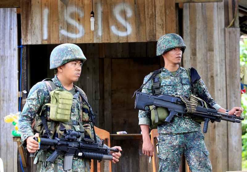 Soldiers stand guard along the main street of Mapandi village as government troops continue their assault on insurgents from the Maute group, who have taken over large parts of Marawi City, Philippines June 2, 2017.u00c2u00a0u00e2u20acu201d Reuters pic