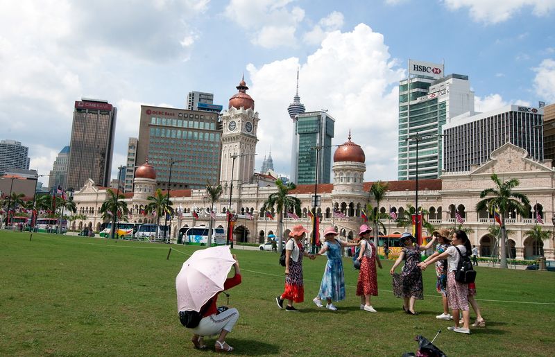 Foreign tourists take the opportunity to snap pictures with the backdrop of the Sultan Abdul Samad Building at Dataran Merdeka during Aidilfitri, June 25, 2017. u00e2u20acu201d Bernama pic