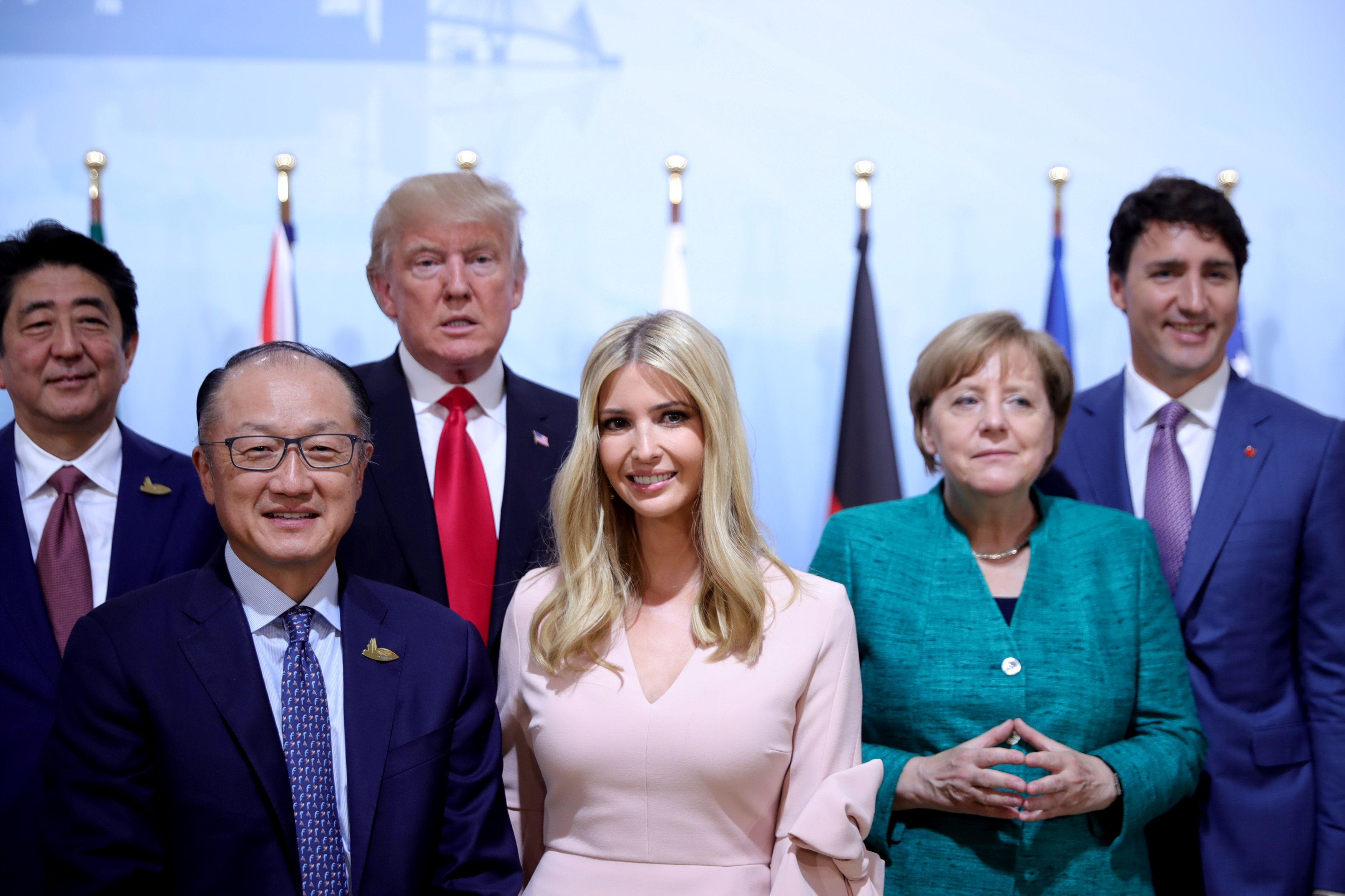 伊万卡（中）在G20峰会上抢镜头，站在其身后的默克尔看似一脸不屑。-路透社-