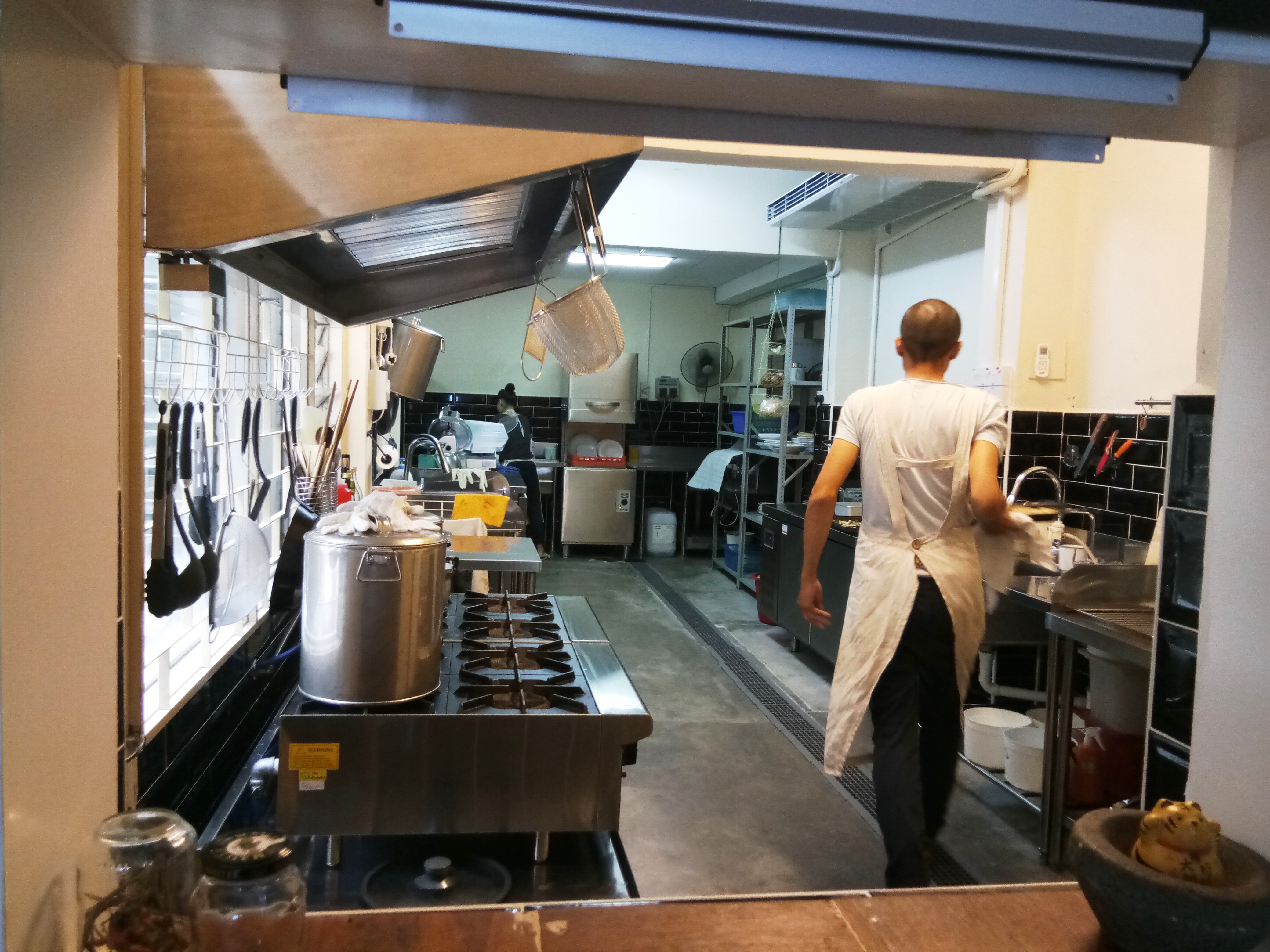 正在厨房忙着烹调美食的老板。-杨琇媖摄-