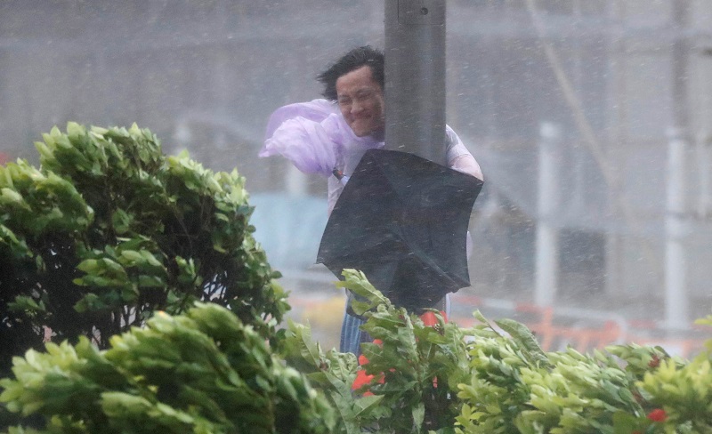A man holds onto a lamp post against strong wind as Typhoon Hato hits Hong Kong, China August 23, 2017. u00e2u20acu201d Reuters pic