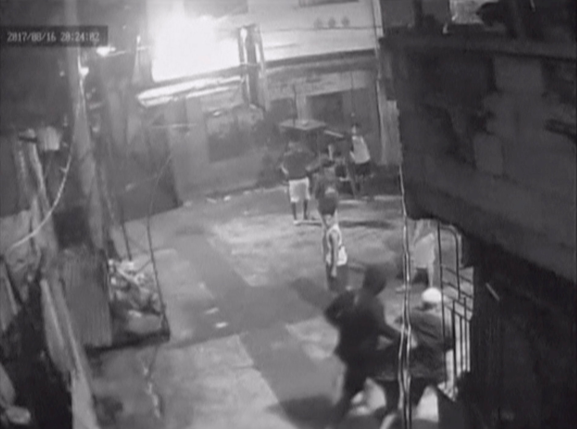 闭路电视片段显示，桑托斯（右下角中）遇害前被两名便衣警察押着走。-路透社