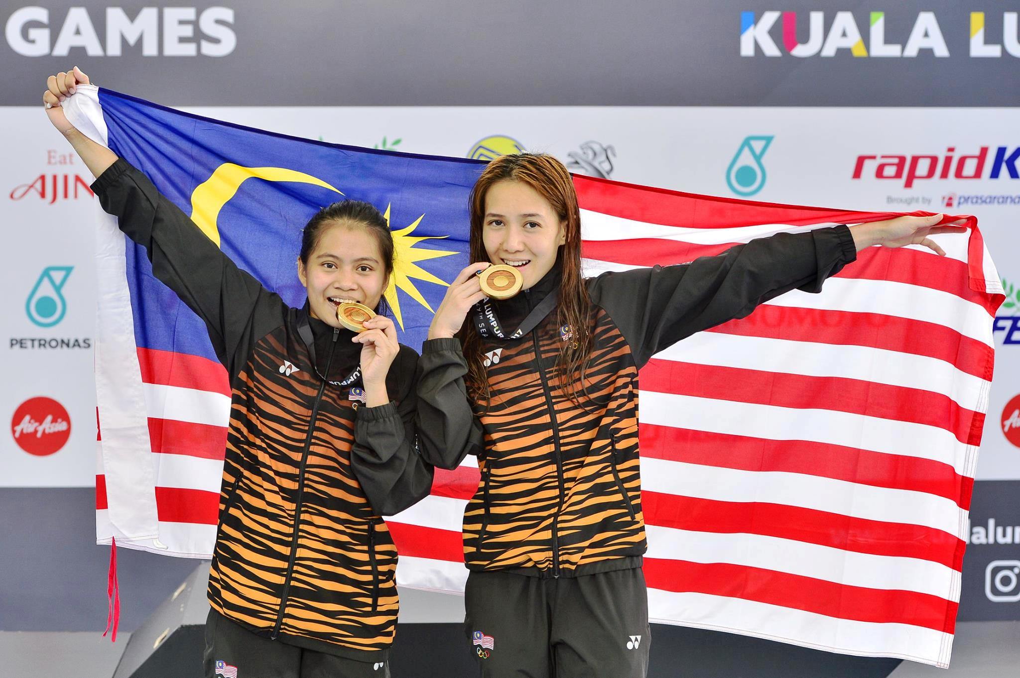 怡保跳水美女梁敏仪（右）和上届搭档特雷西，成功卫冕女子双人十米跳台赛项，摘下她个人第17枚东运金牌。-摘自大马体理会FB-