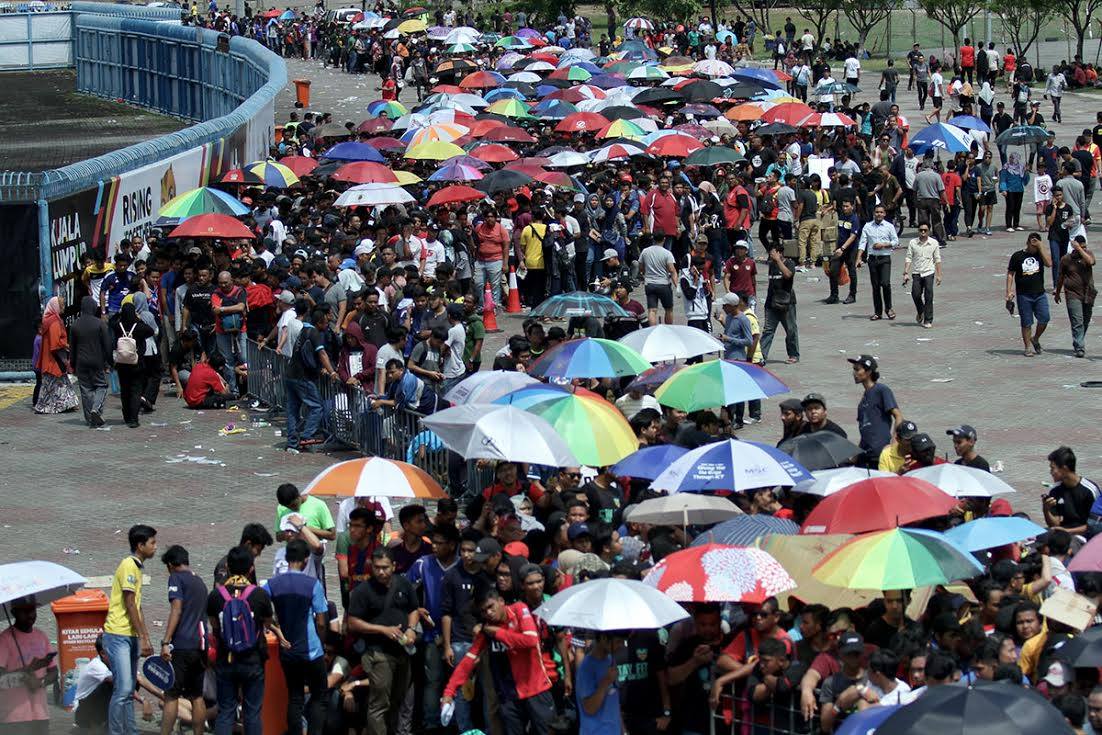 全国各地球迷赶到沙亚南体育馆外漏夜排队，甚至还要在烈日下撑伞，就只为了买票进场支持球队。-马来邮报摄-