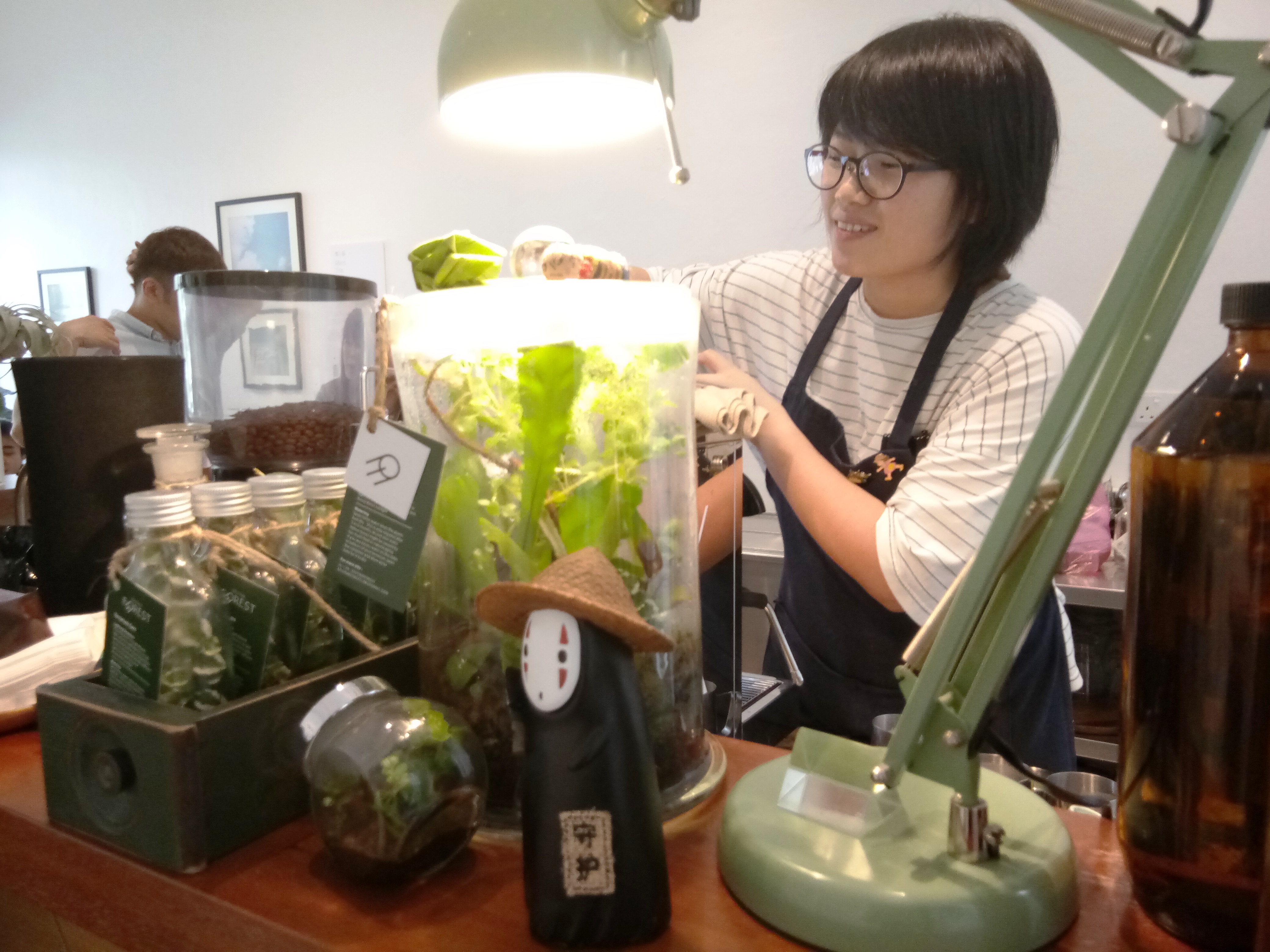 咖啡师洁敏在柜台内忙着冲泡咖啡。-杨琇媖摄-