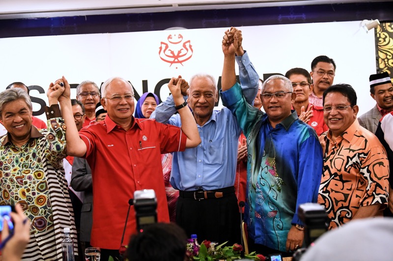 Datuk Seri Najib Razak mengangkat tangan bersama Tan Sri Muhammad Muhd Taib setelah beliau mengumumkan penyertaan semula ke dalam Umno. u00e2u20acu201d Foto Bernama