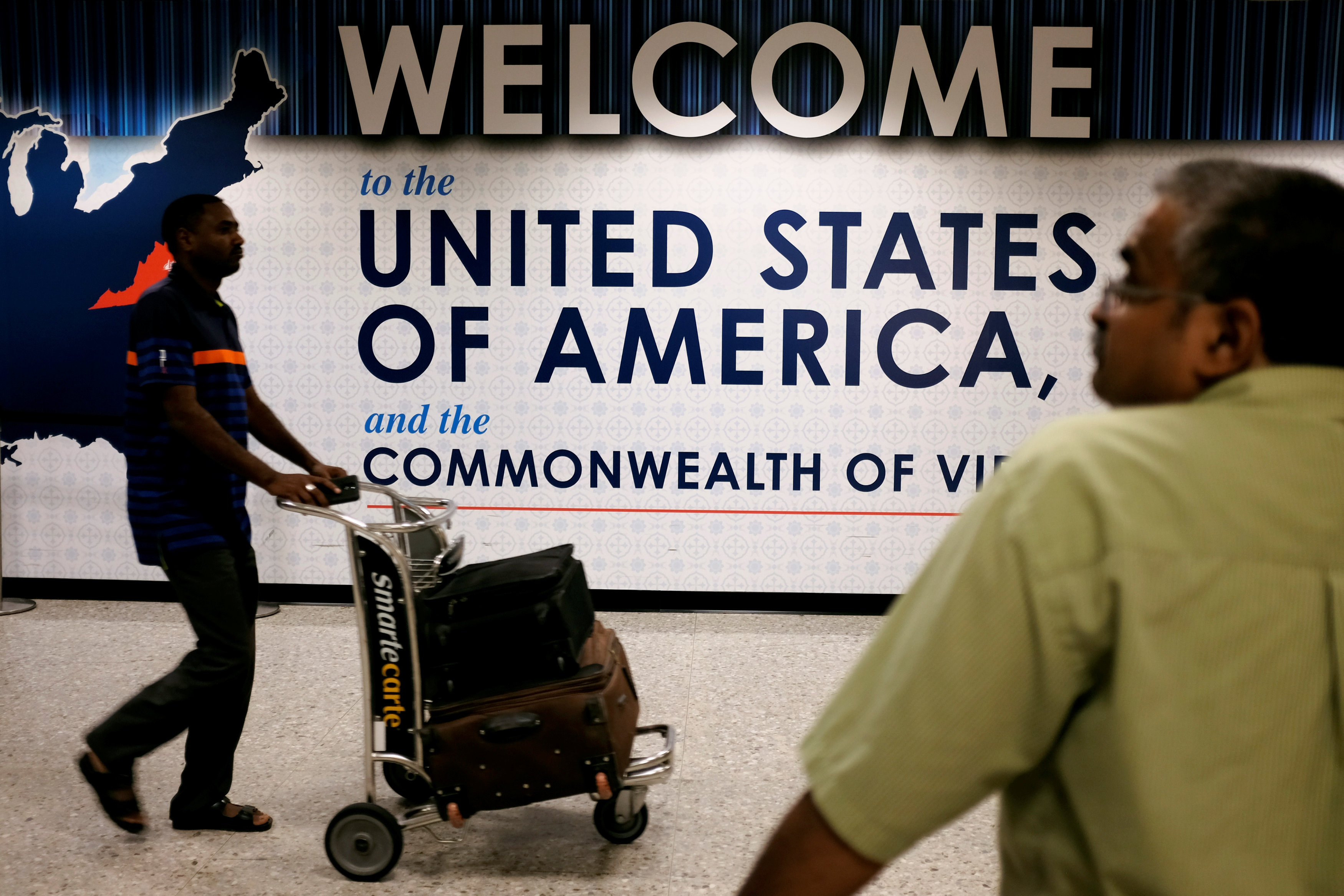 An international passenger (left) arrives at Dulles International Airport as a man waits for loved ones to arrive in Dulles, Virginia, September 24, 2017. u00e2u20acu201d Reuters pic