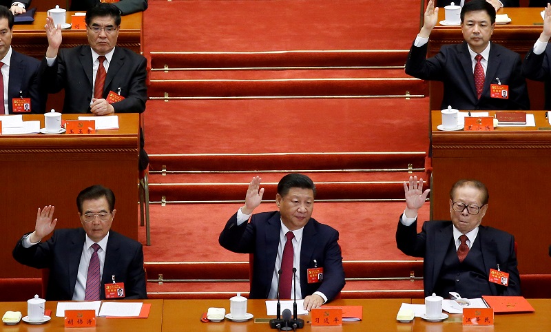 (L to R) Former Chinese president Hu Jintao, Chinese President Xi Jinping and former Chinese president Jiang Zemin raise their hands as they take a vote at the closing session of the 19th National Congress of the Communist Party of China, in Beijing, Chin