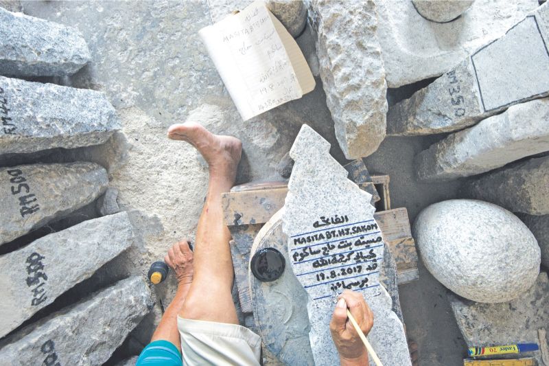 Kuah seen here carving epitaphs using the calligraphy ink as a guideline to make deeper incisions for him to write over the inscription again so the ink stays. u00e2u20acu2022 Picture by Mukhriz Hazim