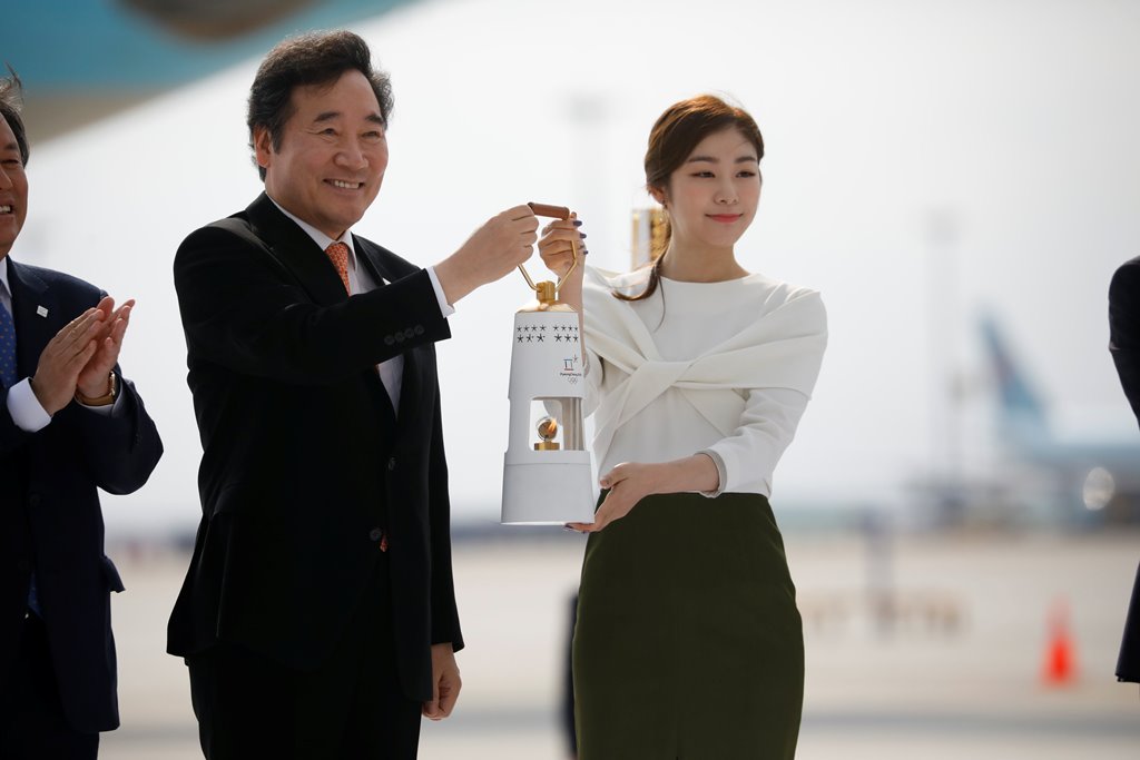 Honorary Ambassador Yuna Kim and Prime Minister Lee Nak-yon carry the Olympic flame at the Incheon International airport in Incheon November 1, 2017. u00e2u20acu201d Reuters picn