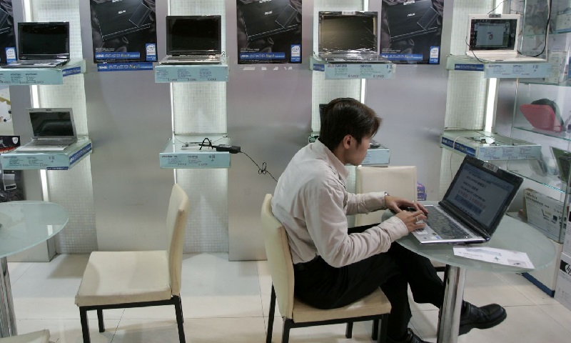 A man works in front of a wall display of Asus laptops at a shop in Taipei January 29, 2008. Photo: Reuters