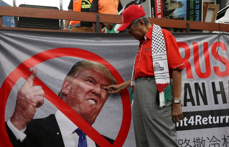 Malaysia's former prime minister Mahathir Mohamad gestures at a U.S. President Donald Trump banner as pro-Palestine supporters protest near the U.S. Embassy in Kuala Lumpur, Malaysia December 15, 2017. REUTERS/Stringer TPX IMAGES OF THE DAY