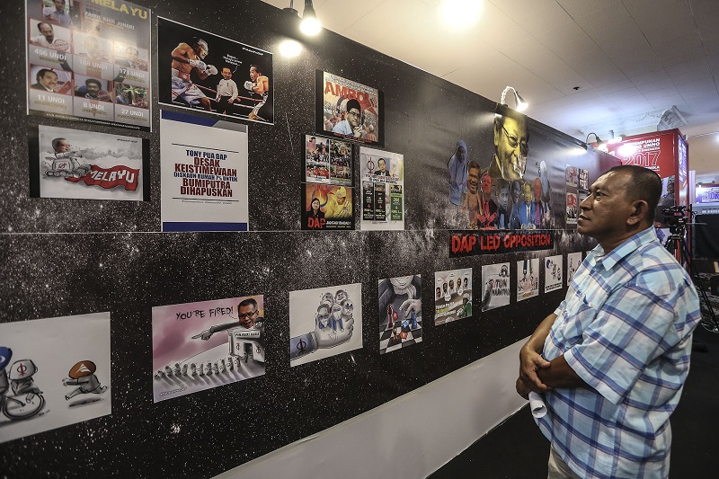 Visitors browse an anti-Pakatan Harapan exhibition at Putra World Trade Centre during the Umno General Assembly in Kuala Lumpur December 5, 2017. u00c2u00acu00e2u20acu201d Picture by Yusof Mat Isa.
