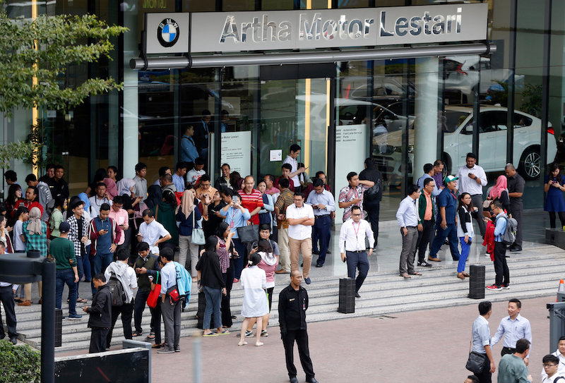 Office workers leave a building following an earthquake in Jakarta, January 23, 2018. u00e2u20acu201d Reuters pic