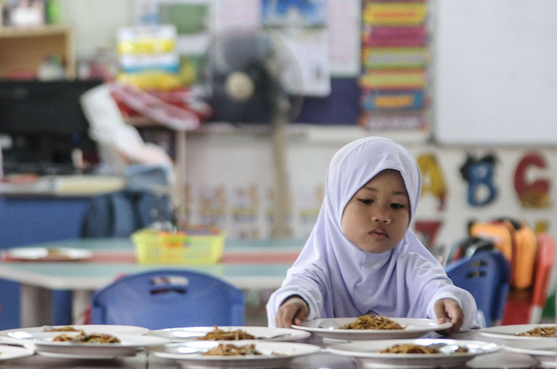 A preschool student eats breakfast on her first day of school in Puchong January 2, 2018. u00e2u20acu201d Picture by Miera Zulyana