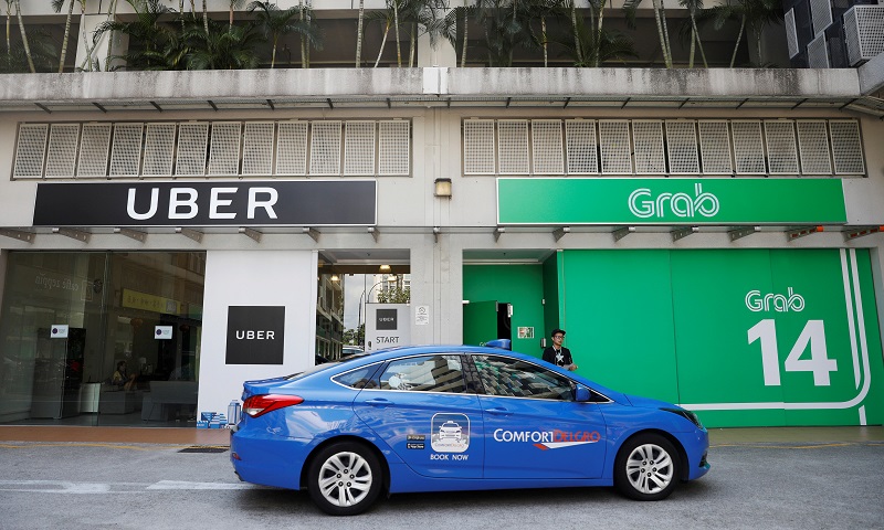 A ComfortDelgro taxi passes Uber and Grab offices in Singapore March 26, 2018. REUTERS/Edgar Su TPX IMAGES OF THE DAY