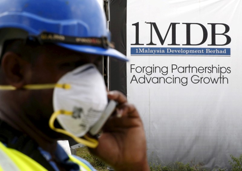 A construction worker talks on the phone in front of a 1Malaysia Development Berhad (1MDB) billboard at the Tun Razak Exchange development in Kuala Lumpur February 3, 2016. u00e2u20acu201d Reuters pic