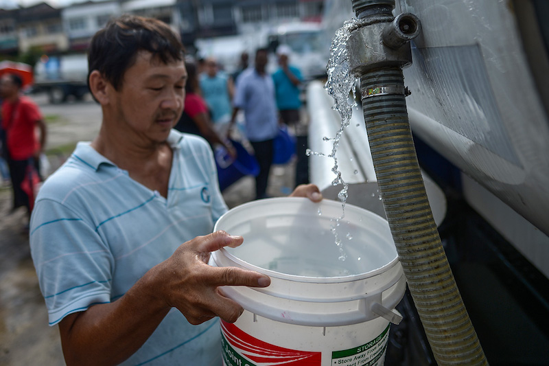 Bandar Kinrara residents fill containers at a temporary water supply centre provided by Syabas at Bandar Kinrara, Puchong March 8, 2018. u00e2u20acu201d Picture by Mukriz Hazim