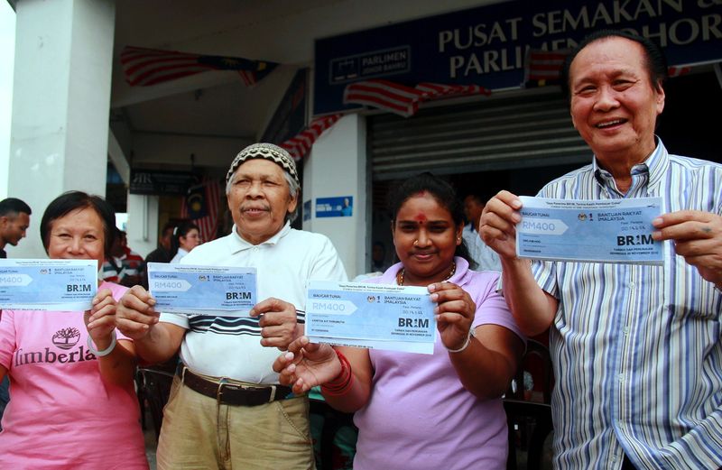 Penerima BR1M (dari kanan) Ong Kim Hoo, 72, Vanitha Thirumuthi, 27, Mohmed Daud, 71, dan Koh Amoi, 63, menunjukkan baucar BR1M yang diterima mereka, 2 Mac 2018 u00e2u20acu201d Foto Bernama