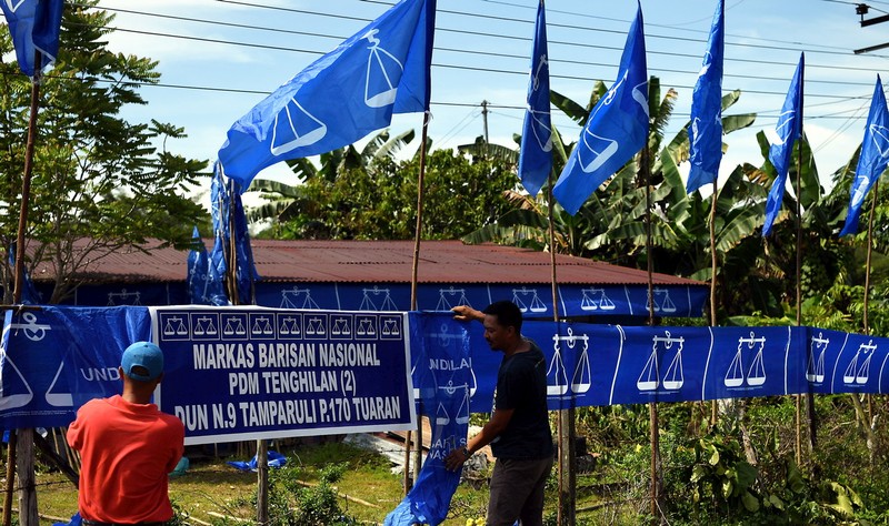 Two Sabah Barisan Nasional (BN) election workers putting up a party banner at the BN headquarters in Tenghilan, Tamparuli district about 30 kilometres from Tuaran March 17, 2018. u00e2u20acu201d Bernama pic