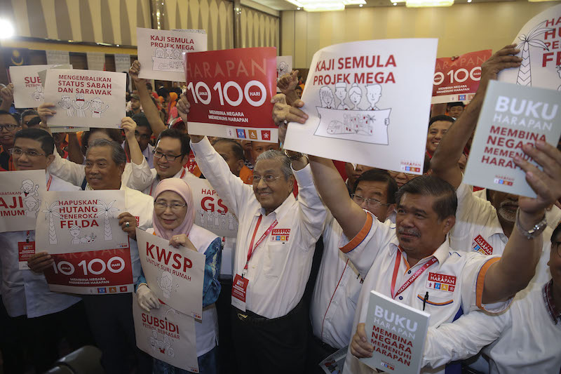 Pakatan Harapan leaders pose for photos while holding banners with manifesto pledges after the launch of Buku Harapan in Shah Alam March 8, 2018. u00e2u20acu201d Picture by Yusof Mat Isa
