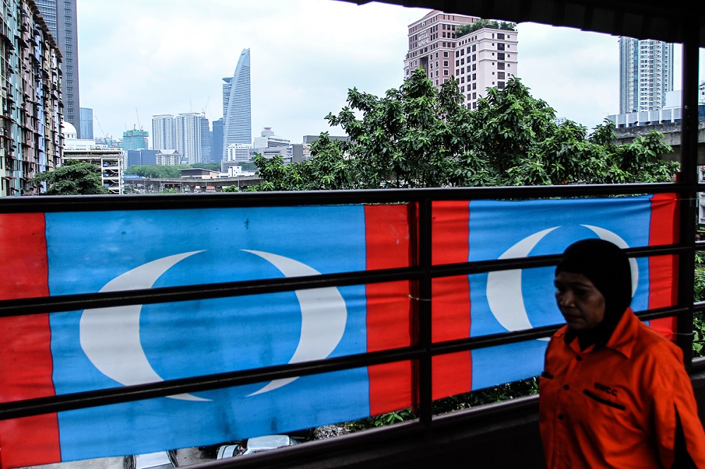 A woman walks past PKR flags near PPR Abdullah Hukum in Bangsar April 16, 2018. u00e2u20acu201d Picture by Shafwan Zaidon