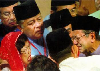 马哈迪当年在巫统大选上突然宣布辞职，巫统领袖们纷纷上前挽留，而拉菲达（红头巾者）更是激动。-图取自网络-