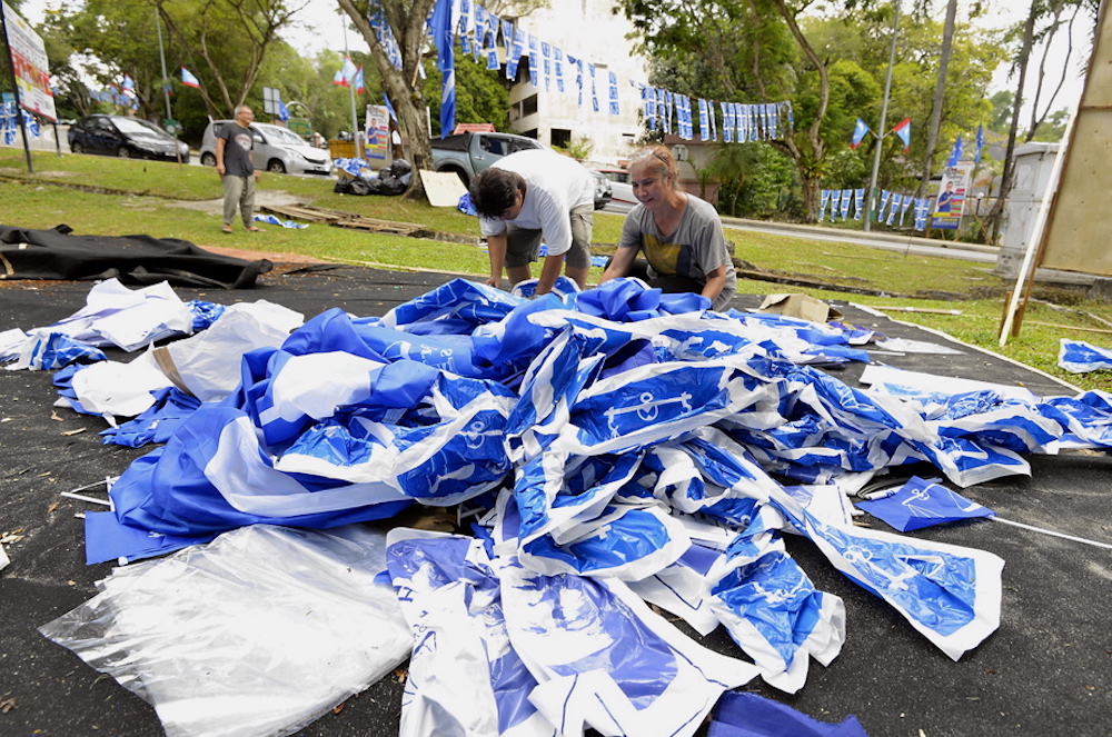 Volunteers clean up BN flags and banners at Bukit Antarabangsa after the conclusion of the 14th general elections, May 10, 2018. u00e2u20acu201d Picture by Ham Abu Bakar