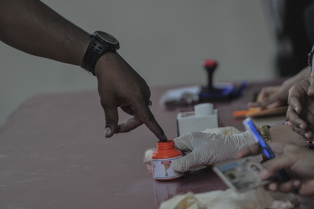 An Election Commission officer dips a voteru00e2u20acu2122s finger in indelible ink during early voting for GE14 at Kem Mahkota Kluang in Johor May 5, 2018. u00e2u20acu201d Picture by Shafwan Zaidon